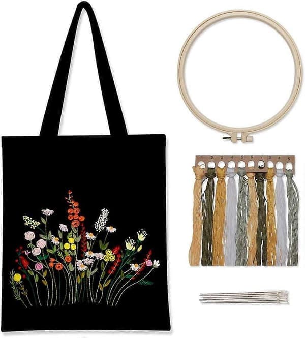Broderisett på svart lerret med mønster og instruksjoner, inkluderer en broderiveske med blomstermønster, broderirammer i bambus, C-tråder