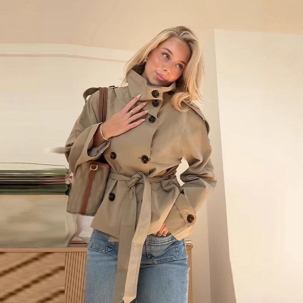 Kort dame-trenchcoat med høy krage, blå denimjeans og brun crossbody-veske, avslappet chic antrekk cm burgunder farge